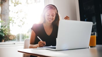 woman with headphones on working on laptop