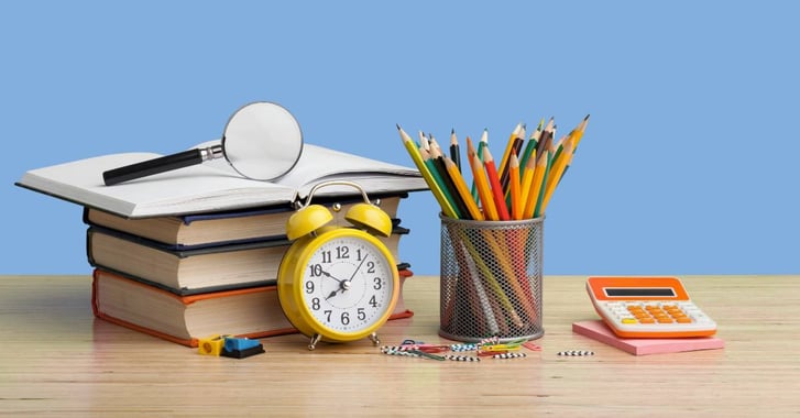 Pile of books and stationary on a desk