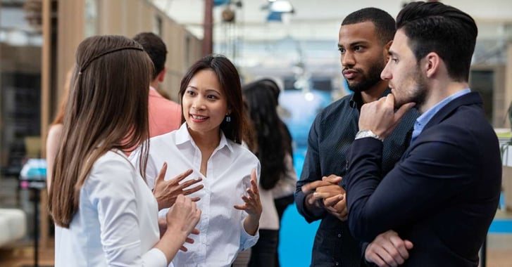 4 people in standing in discussion at event