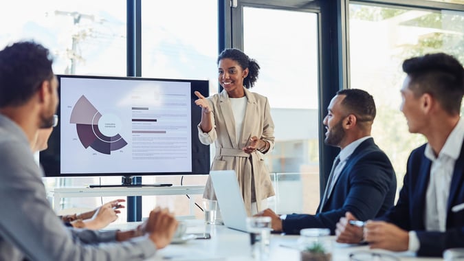 Female leader presenting at a table to her team