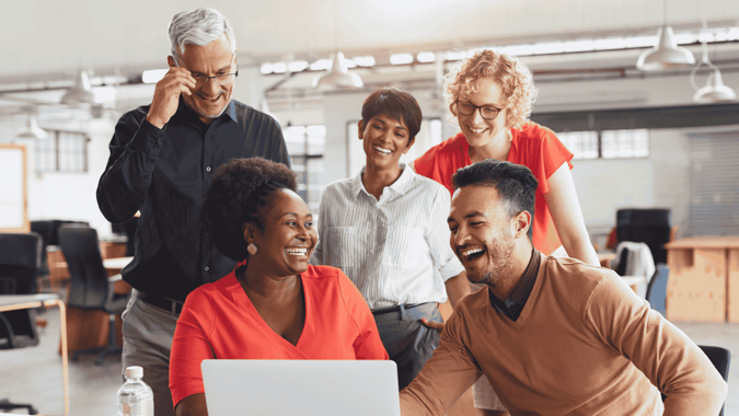 5 people of different ages working and smiling together